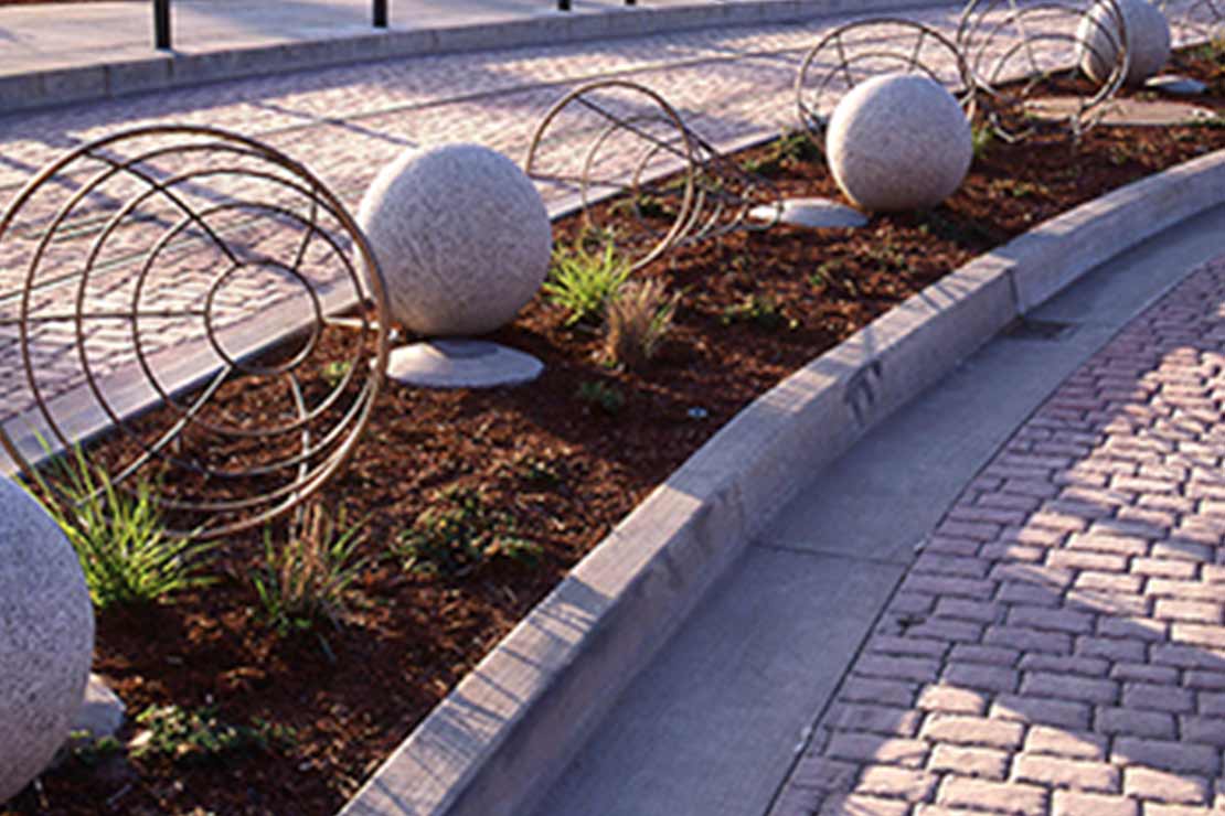 Planting strip with concrete orbs and wire frame sculputures