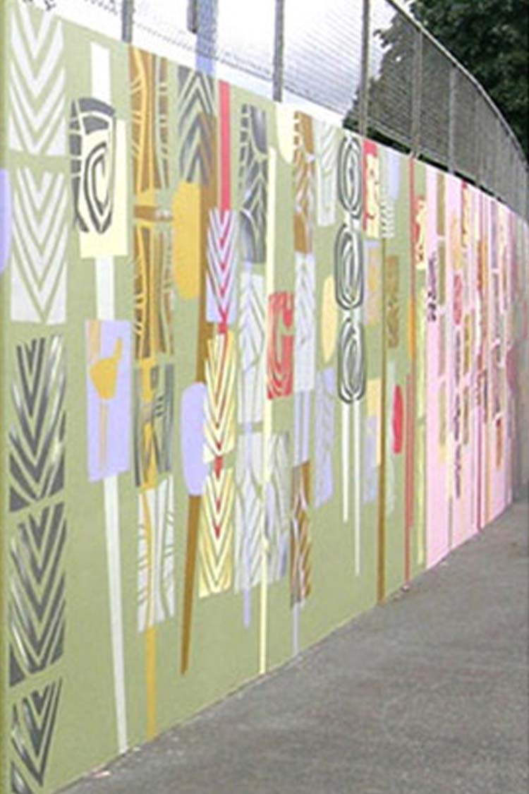 Mural in green and pink with repeated circular and angular patterns