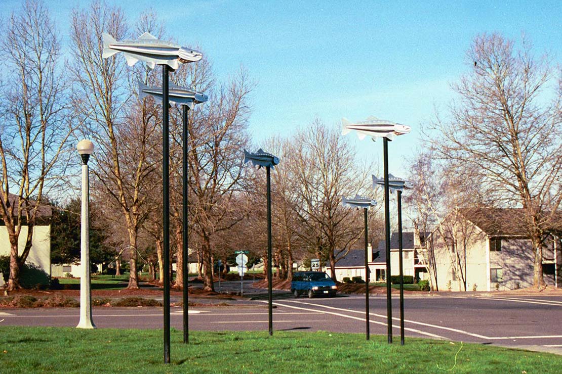 Coho Commute sculpture garden with coho on tall metal poles