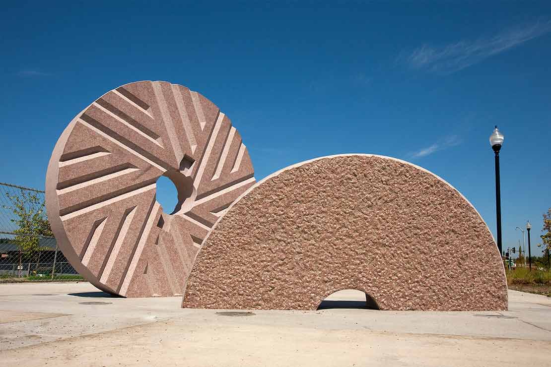 'Threshhold'- a large wheel & a half wheel made of sculpted granite standing vertically